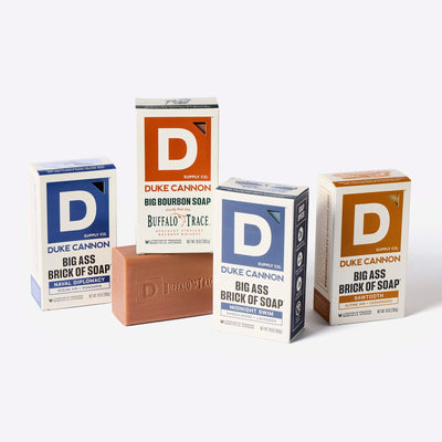 Four boxes of Duke Cannon Big Ass Bricks of soap on a white background. Scents present: Naval Diplomacy, Bourbon, Midnight Swim and Sawtooth.