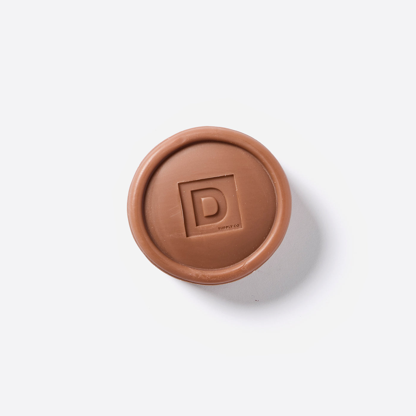 Puck shaped Bar of Soap with the Duke Cannon logo in the middle. 