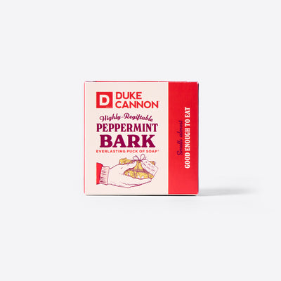 The back of the Duke Cannon Highly Regiftable Peppermint Bark Everlasting Puck of Soap packaging with the Soap Puck on the inside. On a white background. Says, "Smells almost good enough to eat."