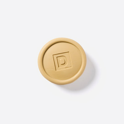 Puck shaped Bar of Soap with the Duke Cannon logo in the middle. 