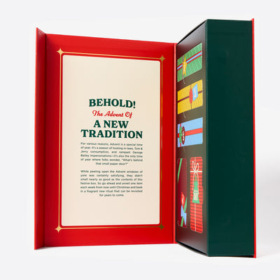 The inside of the cover of the Duke Cannon Kinda-Sorta advent calendar box with Christmas tree and gift illustrations on a white background. Says, "Behold! The Advent of a new tradition".